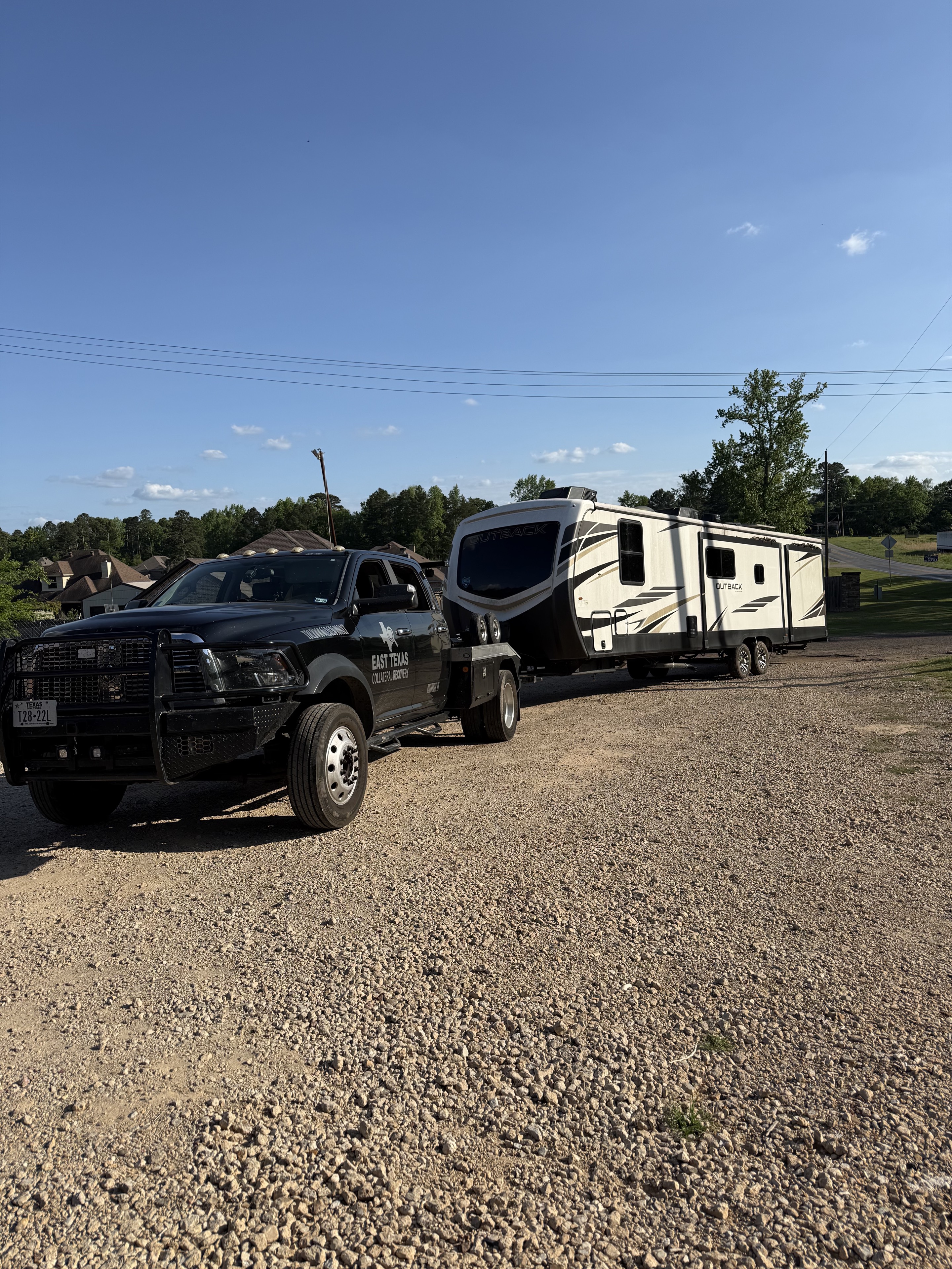East Texas Collateral Recovery truck transporting an Outback travel trailer